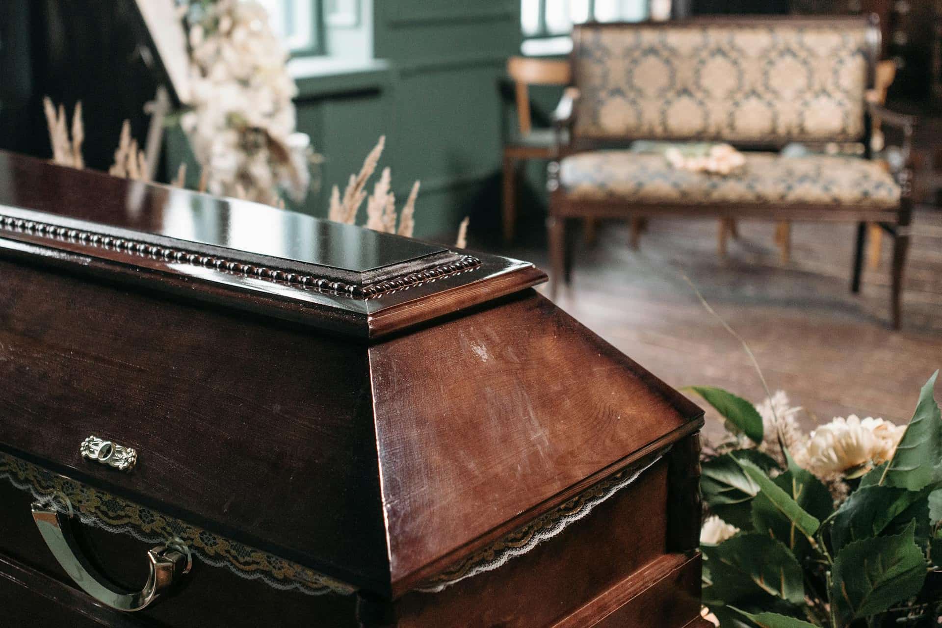Wooden coffin in room with flowers