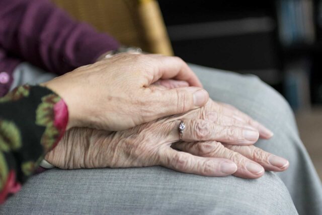 Elderly people holding hands