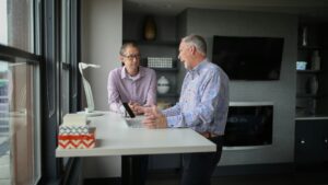 Two older employees talking in office