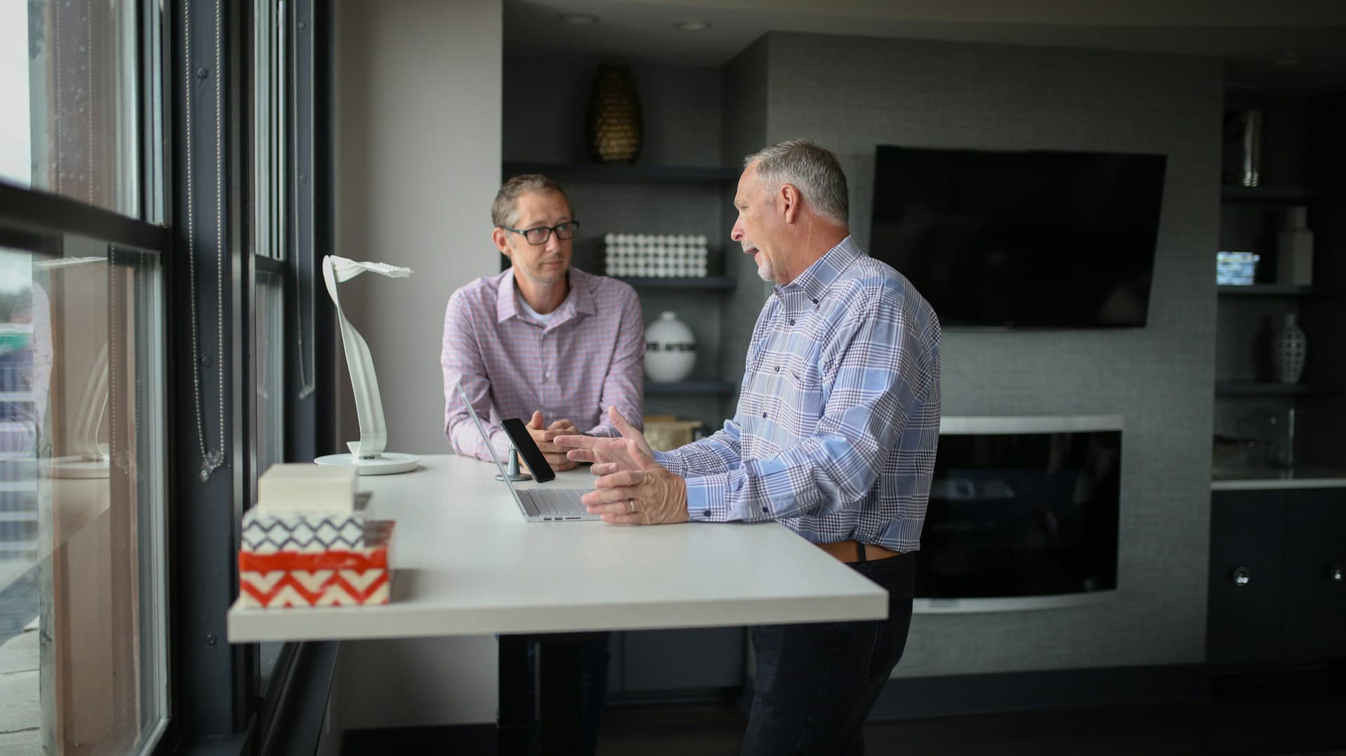Two older employees talking in office